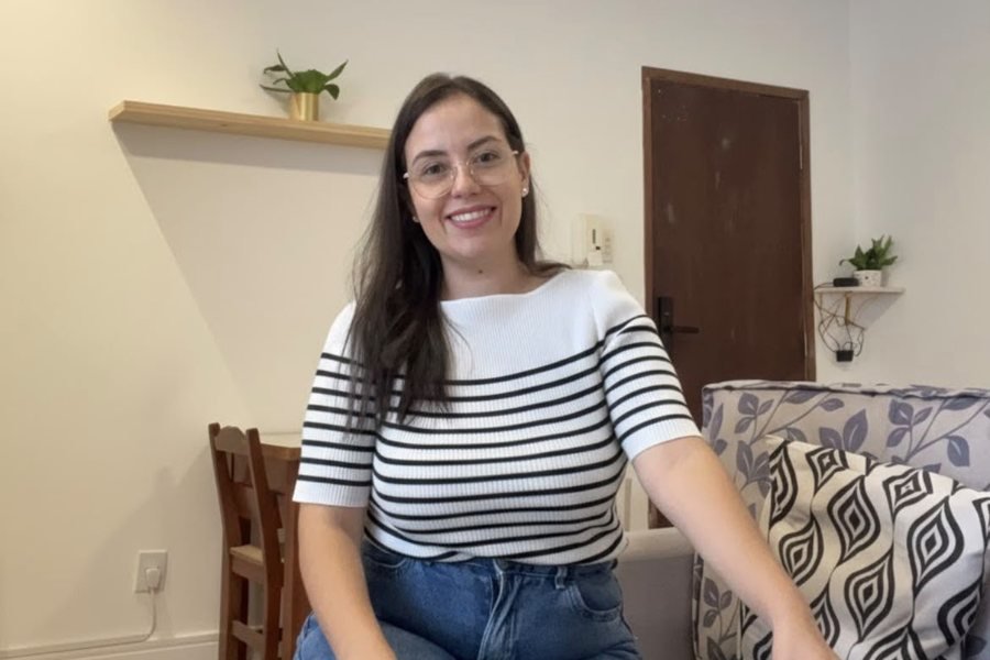 Natália Vasconcelos, psicóloga, sentada em ambiente acolhedor